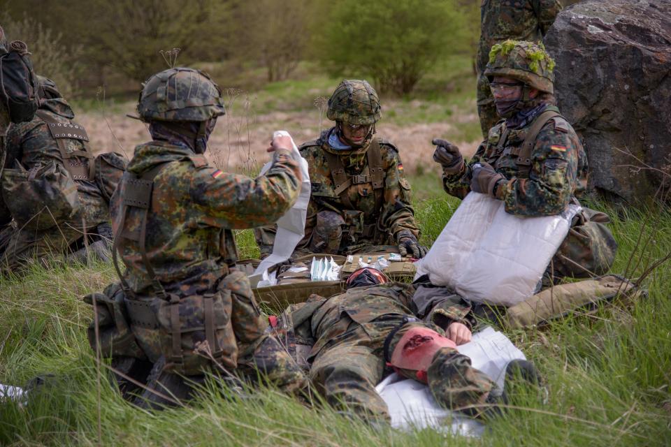 Drei Soldaten versorgen einen verletzten Kameraden